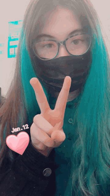 a girl wearing glasses and a mask giving a peace sign on january 12