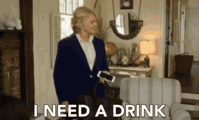 a woman standing in a living room with the words i need a drink