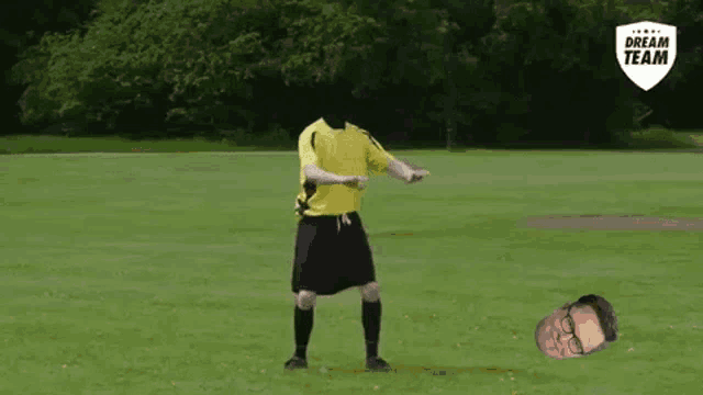 a soccer player without a head is dancing on a field with a man laying on the ground .