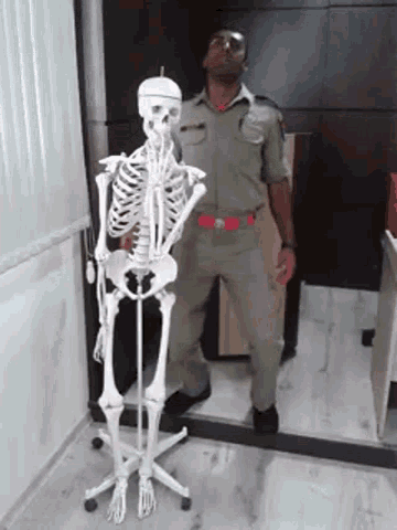 a man standing next to a skeleton statue