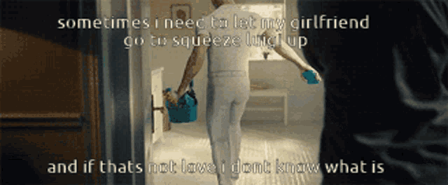 a man is holding a bucket and a spray bottle while walking into a room