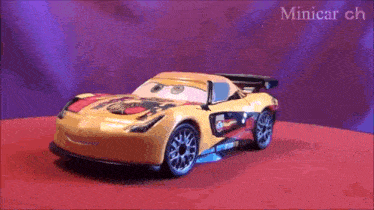 a toy car from the movie cars is on a red surface .