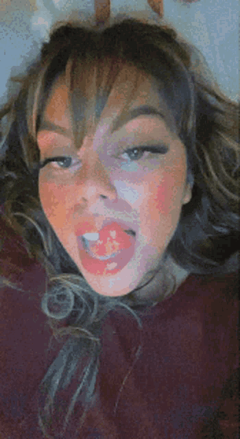 a woman is sticking her tongue out while wearing a red shirt