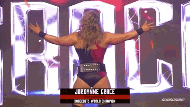 a female wrestler is standing in front of a sign that says jordynne grace knockouts world champion