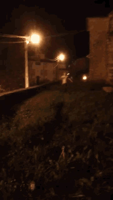 a person laying in the grass at night