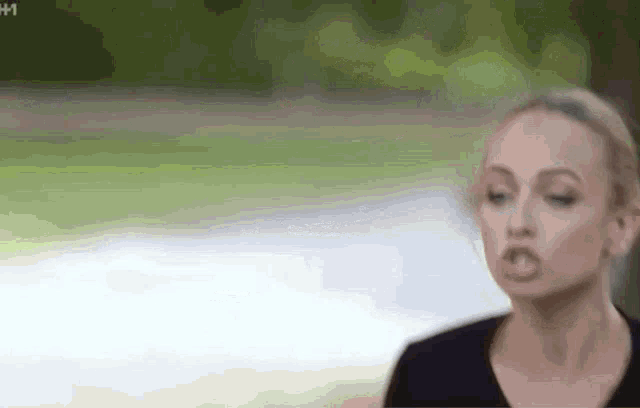 a woman in a black shirt is making a funny face with her mouth open .