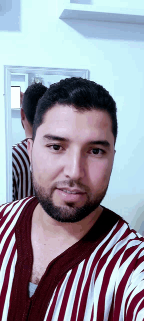 a man with a beard is wearing a striped shirt