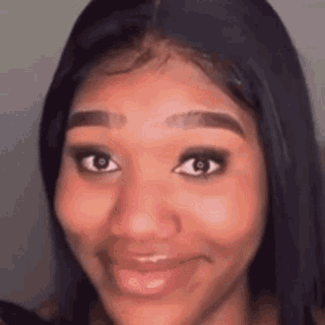 a close up of a woman 's face with a wig on smiling .