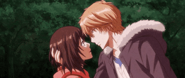 a boy and a girl are looking into each other 's eyes in a forest .