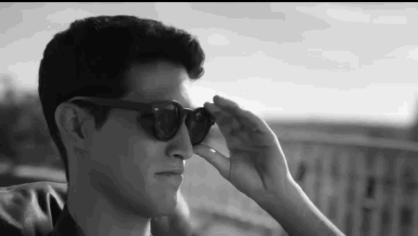 a man wearing sunglasses looks at something in the distance