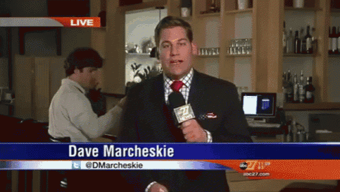a man holding a microphone with the name dave marcheskie on the bottom