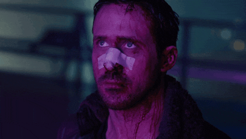 a man with a bandage on his nose looks to the side