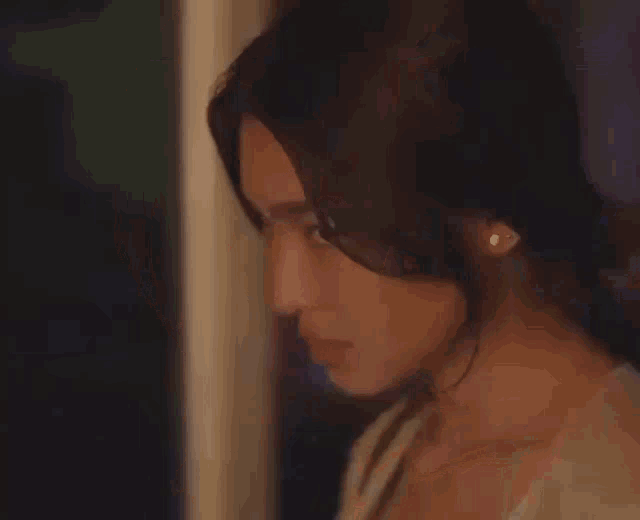 a close up of a woman 's face behind a window with a blurred background .