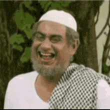 a man with a beard and a white hat is laughing and smiling .