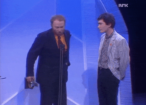 two men on a stage with the letters nrk on the bottom left
