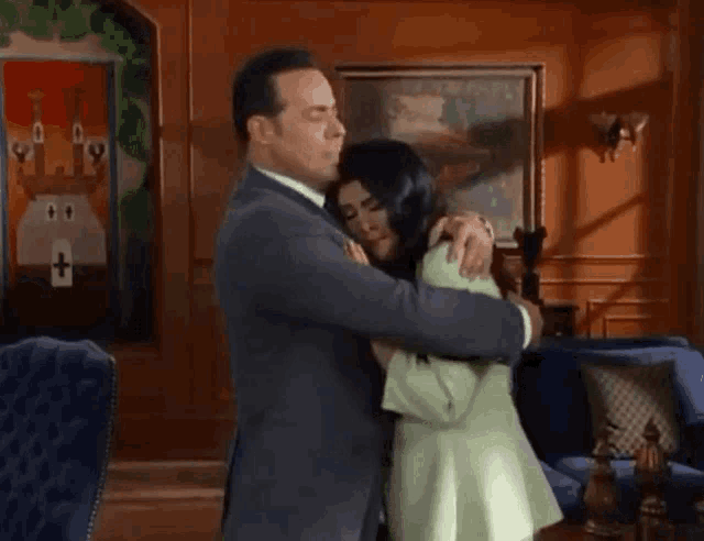 a man is kissing a woman on the forehead in a room .