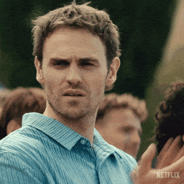 a man in a blue striped shirt has a netflix logo on the bottom right