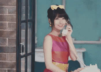 a woman in a colorful dress is talking on a white telephone .
