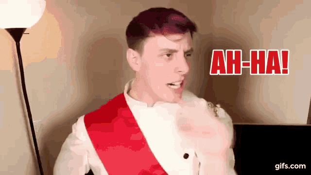 a man with purple hair and a red sash around his neck is making a funny face and saying ah-ha !
