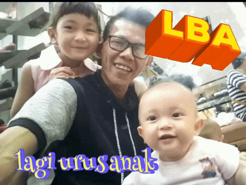 a picture of a man holding a baby with the words lagi urusanak on the bottom right