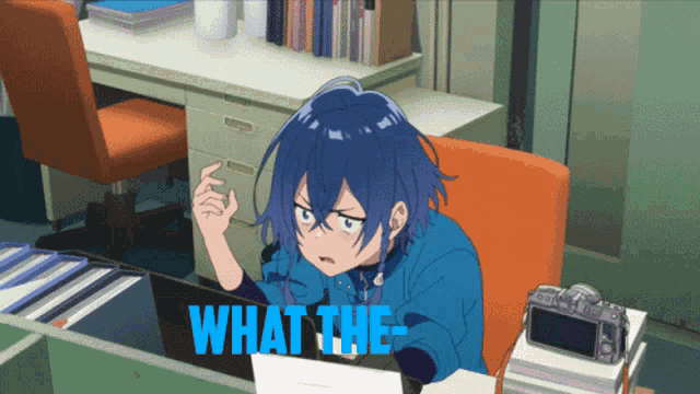 a blue haired anime character is sitting at a desk looking at a laptop with the words " what the " written in blue