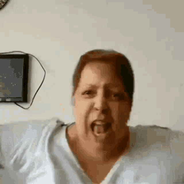 a woman is making a funny face with her tongue hanging out .