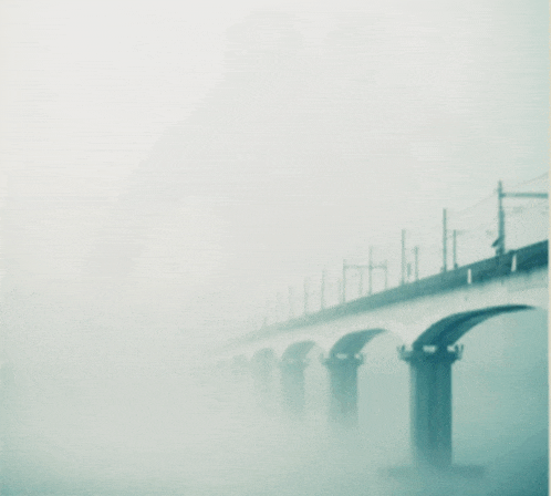 a bridge in the fog with a few lines visible