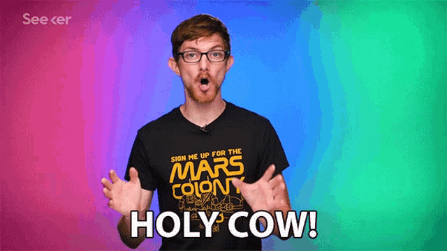 a man wearing glasses and a black shirt that says holy cow