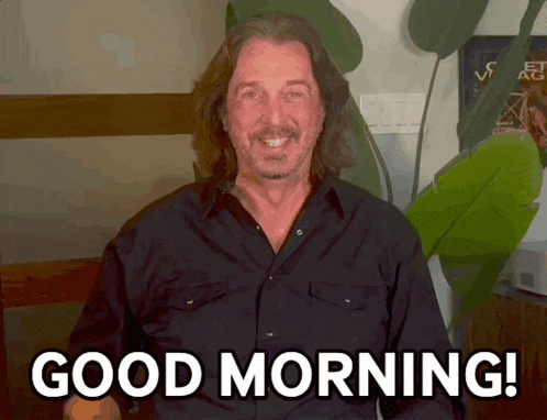 a man in a black shirt is smiling and says good morning