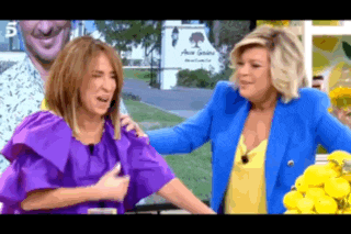 two women are standing next to each other and one of them is wearing a purple dress .