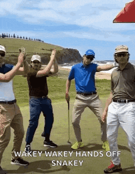 a group of golfers are standing on a golf course giving each other high fives .