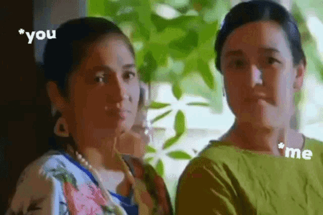 two women are standing next to each other and talking to each other .