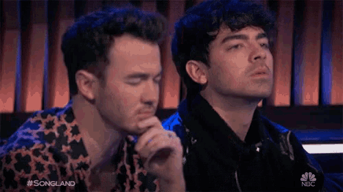 a couple of men sitting next to each other with the words songland on the bottom