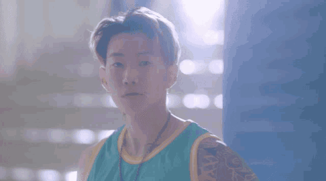 a young man with a tattoo on his arm is wearing a blue and yellow jersey