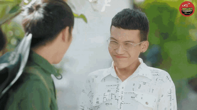 a man wearing glasses is talking to another man with a red sign that says central coffee on it