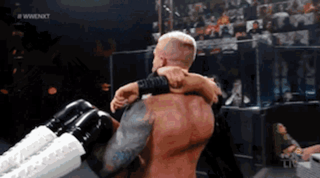 a wrestler is carrying another wrestler in his arms .