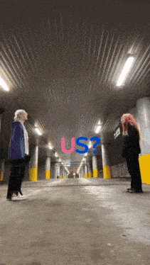 two girls are standing in a parking garage with the words us written on the ceiling