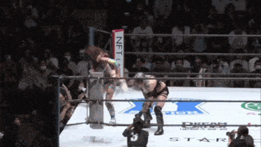 a woman in a wrestling ring with a sign that says nft