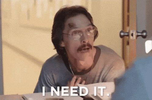 a man with glasses and a mustache is sitting at a table and says i need it .
