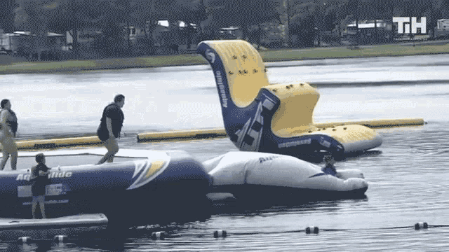 a group of people are playing in a water park with the letters th visible in the background