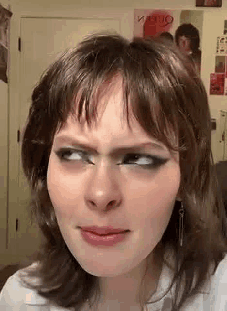 a close up of a woman making a funny face while looking at the camera .