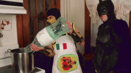 a man wearing an apron with an italian flag on it pours a bottle of water into a pot
