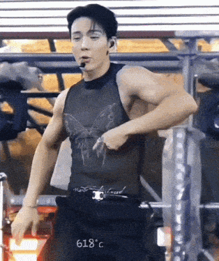 a man is wearing a tank top with a butterfly on it and a belt .