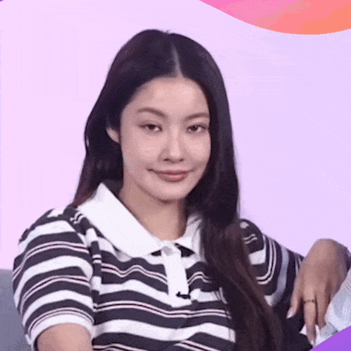 a woman wearing a black and white striped shirt looks at the camera