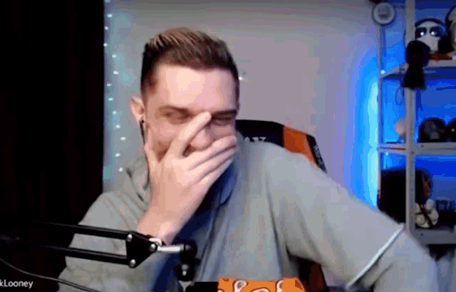 a man is covering his mouth with his hand in front of a microphone .