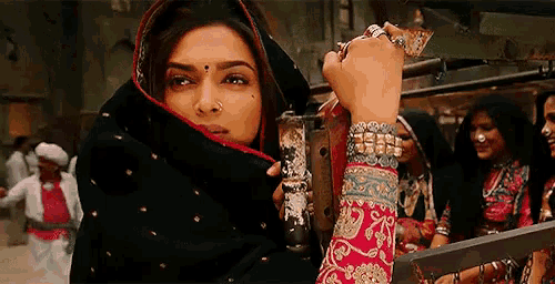 a woman with a veil on her head is holding a sword in her hand .