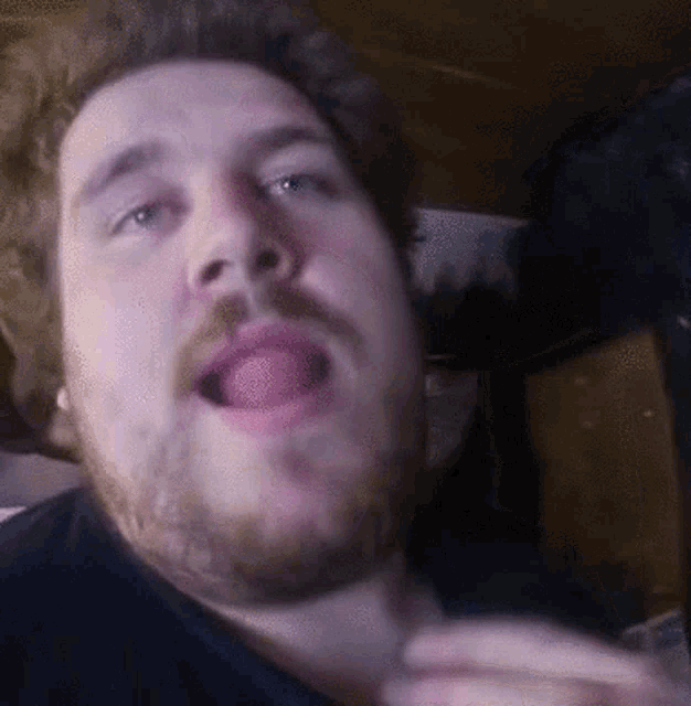 a man with a beard is making a funny face