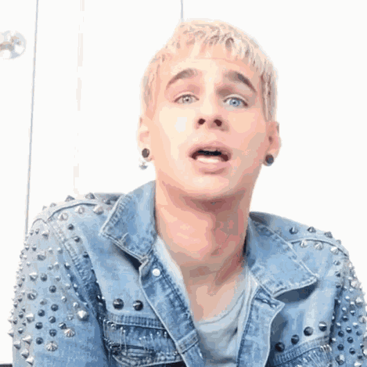 a man wearing a denim jacket with studs on the sleeves