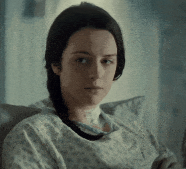 a woman in a hospital gown with a bandage on her neck