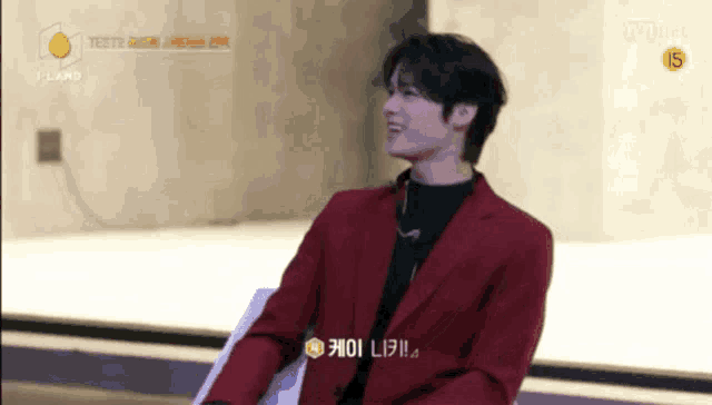 a young man in a red jacket is sitting on a chair .